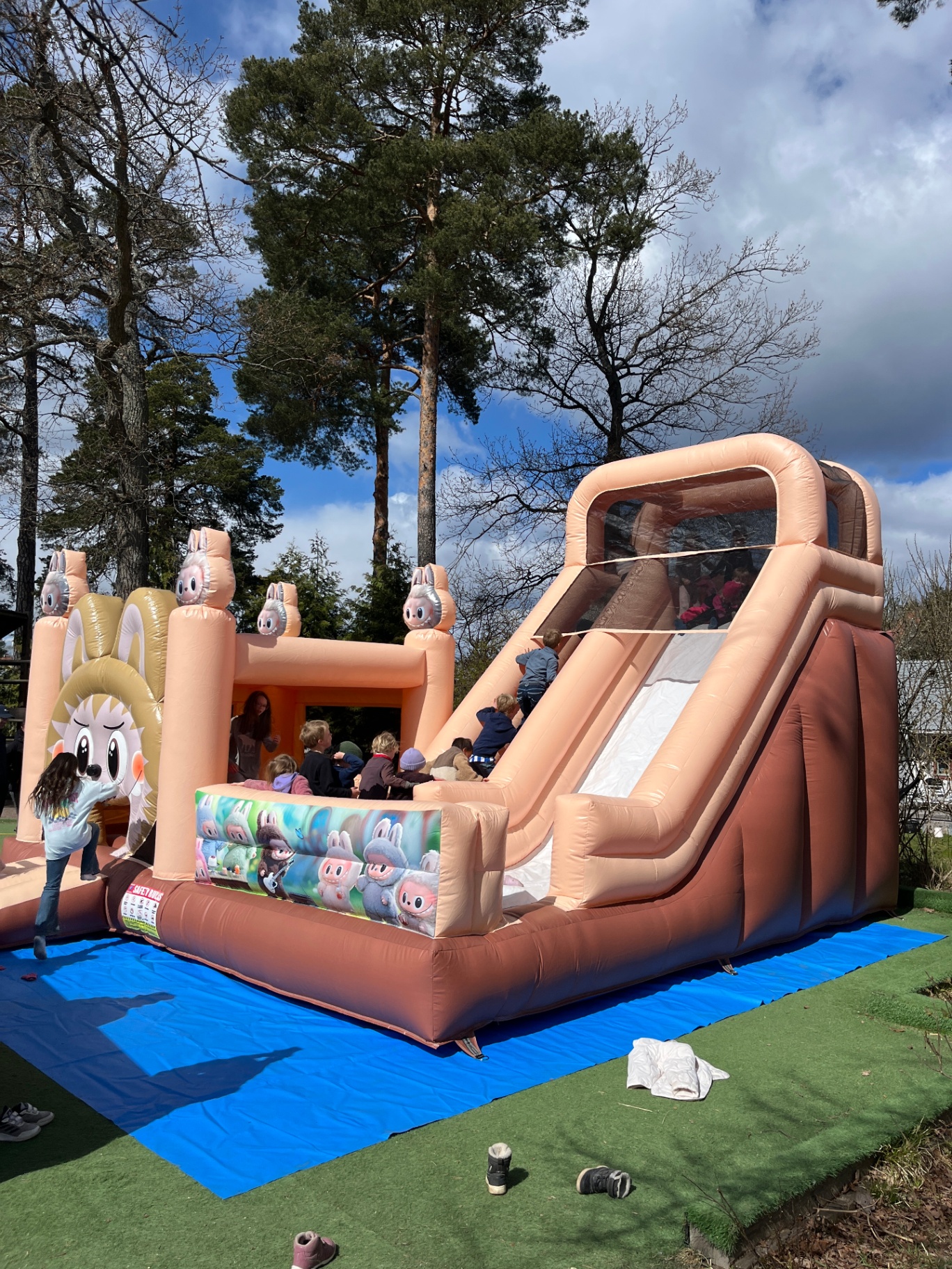 Barn som klättrar upp för rutschkanan på hoppborgen utomhus