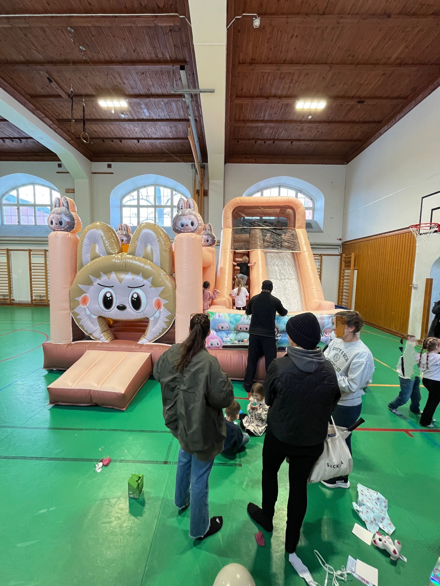 Hoppborg uppställd inomhus i en gymnastiksal med barn och föräldrar